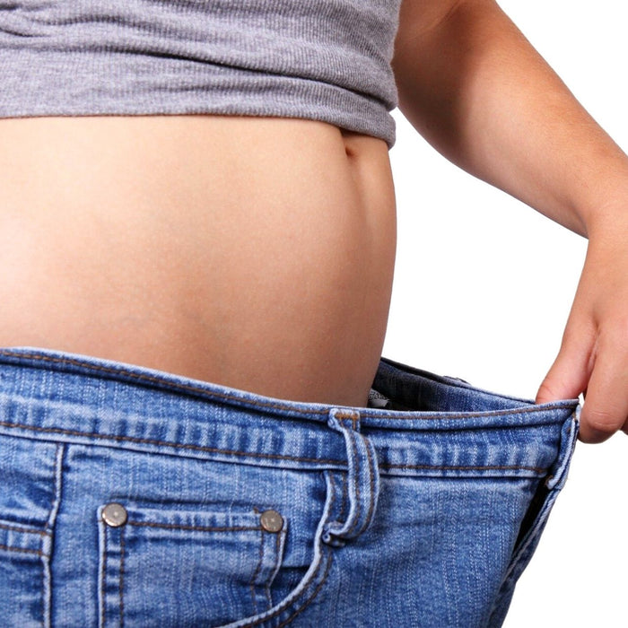 Eine Frau schaut in ihre Hose